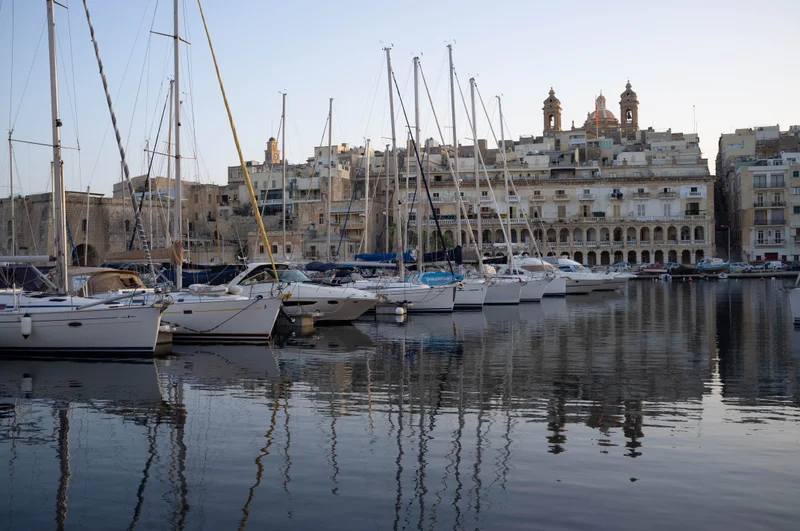 The sun setting on boats docked alongside Senglea, Malta
