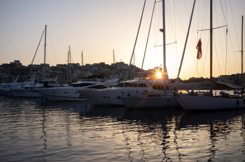 The view of Senglea and Valetta from the Three Cities boat harbour as the sun sets